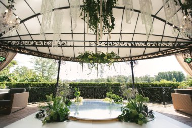 Taze çiçeklerin ve boncuklu avizelerin olduğu bir düğün yeri.