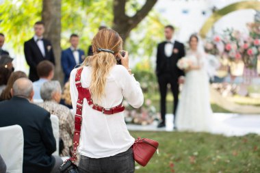 Düğün fotoğrafçısı, gelin ve damadın tören sırasında fotoğraflarını çeker..