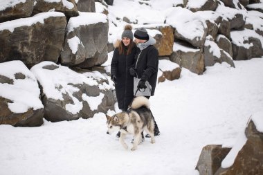 Hoş bir aile, bir erkek ve bir kız ile köpek kış ormandaki. Sibirya husky köpek ile oynamak