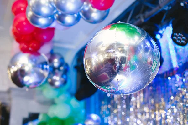 stock image Shiny disco ball and inflatable balloons at the party.