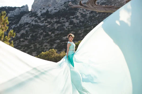 水の近くの山の中で自然の中で花嫁 ドレスの色ティファニー 花嫁は彼のドレスで遊んでいる — ストック写真