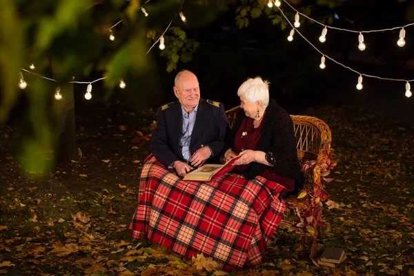 Stock image Happy elderly couple in the Park, grandma and grandpa. Look at the photo album