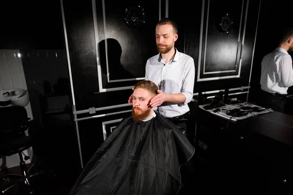 理髪師は理髪店で髪とひげを切ります 美容師ははさみと金属櫛を使用してヘアスタイルを作ります 依頼人の仕事に満足してない — ストック写真
