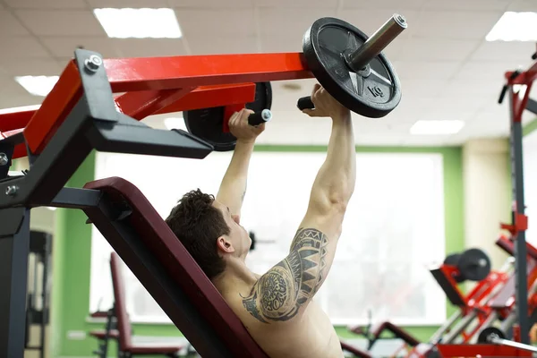 男子在垂直长椅压力机上做胸部运动 — 图库照片
