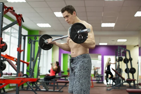 筋肉の男はジムで仕事をしています練習とともにバーベル 強い男性裸胴の腹筋 — ストック写真