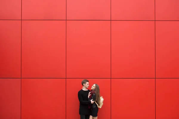 感情の若い男と女性は 赤い壁を背景に 通りに ファッション — ストック写真