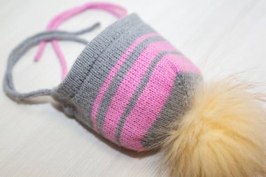 Beyaz arka planda, ponponlu yün şapka ören çocuklar.