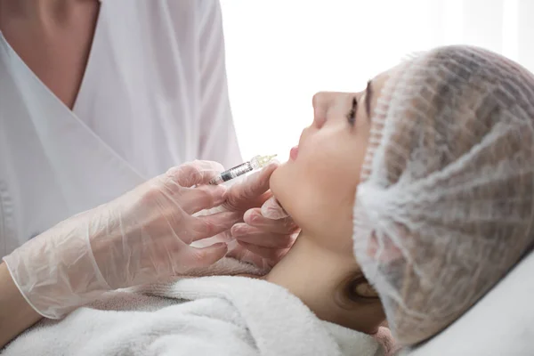 stock image Hands of cosmetologist making injection in face, lips. Young woman gets beauty facial injections in salon. Face aging, rejuvenation and hydration procedures. Aesthetic cosmetology.