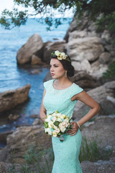 新娘在大自然的山上靠近水 衣服的颜色Tiffany 新娘拿着花束摆姿势 — 图库照片