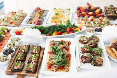 Restorandaki ziyafet masasında çeşit çeşit yemekler var..