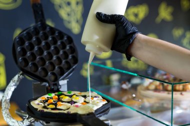 Waffle makinesinin üzerine hamur dökmek. Hong Kong waffle 'ı hazırlanıyor.