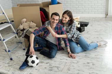 Yeni bir evde genç bir çift büyük kutuların arkasında dinleniyor. Yeni eve taşınma kavramı, birlikte yaşamaya başladık..