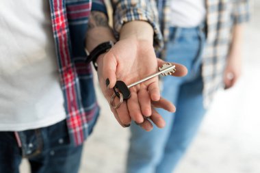 Çift yeni evin anahtarlarını gösteriyor