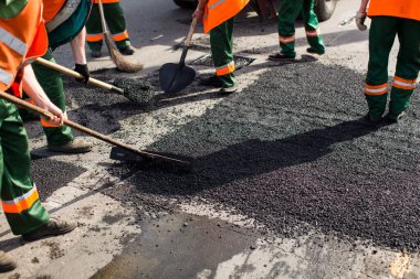 Road Street tamirat sırasında kaldırım makinesinde çalışan işçiler. Sokak yeniden ortaya çıkıyor. Taze asfalt yapısı. Kötü yol.