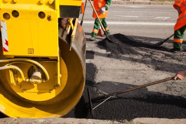 Otoyol inşaatı sırasında çakıl tabanının üstüne yeni asfalt ya da bitumen döşeyen asfalt makinesi.