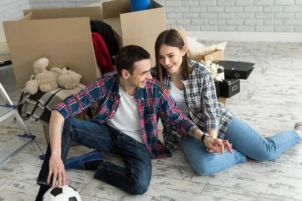 Yeni bir evde genç bir çift büyük kutuların arkasında dinleniyor. Yeni eve taşınma kavramı, birlikte yaşamaya başladık..