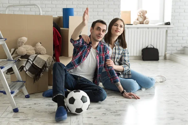 Yeni bir evde genç bir çift büyük kutuların arkasında dinleniyor. Yeni eve taşınma kavramı, birlikte yaşamaya başladık..