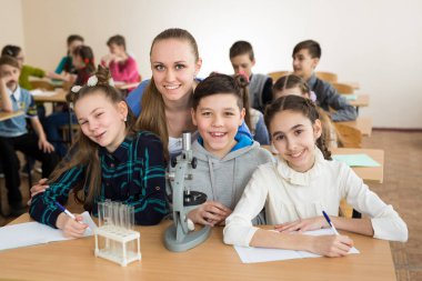 Bilim şişeler ve mikroskop ilköğretim okulunda kullanan öğrenciler