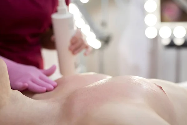 Kosmetikerin Trägt Nach Der Haarentfernung Eine Feuchtigkeitscreme Auf Die Brust — Stockfoto