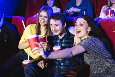 İki genç kız ve sinemada komedi izleyen bir adam. Genç arkadaşlar sinemada film izliyor. Patlamış mısır ve içeceklerle tiyatroda bir grup insan
