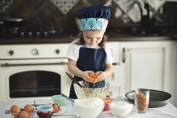 Uma Menina Bonita Avental Chapéu Chefs Quebra Ovo Prato Olhando — Fotografia de Stock