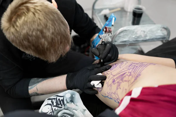 若い女の子の足にタトゥーを作るタトゥー アーティスト — ストック写真