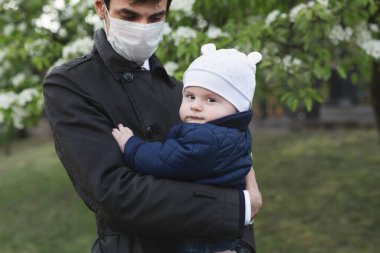 Çocuk ve tıbbi koruyucu maskeli adam sokakta. Virüs salgını.