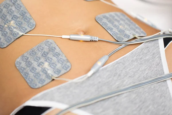 stock image Therapist applying lipomassage on girls body in spa. Close-up of biostimulating apparatus for anti-cellulite lipomassage. Hardware cosmetology