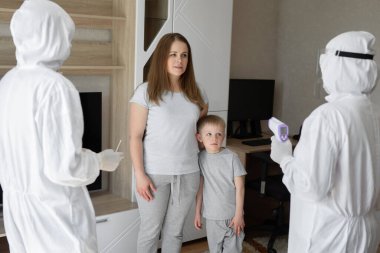 Koruyucu giysili doktorlar evdeki hasta hastalara bakıyorlar. Coronavirus, covid-19