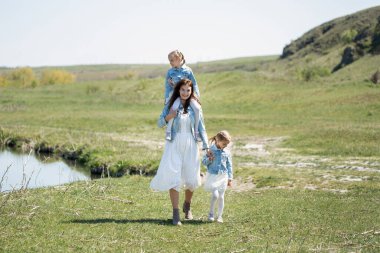 Anne ve ikiz kızları köydeki bir su deposunun yakınlarında yürüyorlar..