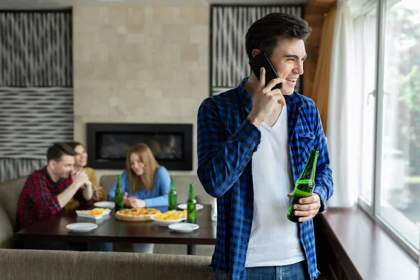 Молодой Человек Пьет Пиво Бутылки Разговаривает Телефону Смотрит Окно Кафе — стоковое фото