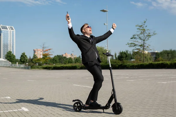 Takım Elbiseli Genç Yakışıklı Işadamı Elektrikli Scooter Kullanıyor Telefonda Konuştuktan — Stok fotoğraf