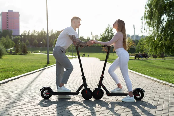 Parktaki Genç Çift Elektrikli Scooter Kullanıyor — Stok fotoğraf