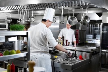 Modern mutfak. Aşçılar bir restoranın ya da otelin mutfağındaki ocakta yemek hazırlarlar.