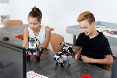 Okul çocukları sınıfta bir robot programlıyor.
