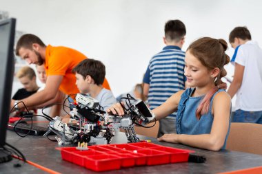 Eğitim, çocuk, teknoloji, bilim ve insan kavramı - grup robotlar robot okul ders bina dizüstü bilgisayar ile mutlu çocuk