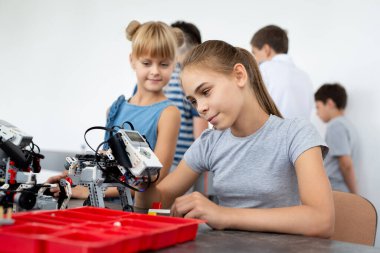 Eğitim, çocuk, teknoloji, bilim ve insan kavramı - grup robotlar robot okul ders bina dizüstü bilgisayar ile mutlu çocuk