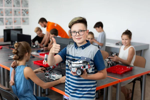 Porträt Eines Glücklichen Schuljungen Mit Einem Roboter Den Selbst Robotikunterricht lizenzfreie Stockfotos