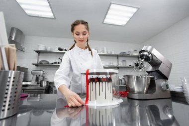 Pasta şefi pastayı süslü bir kutuda paketliyor..