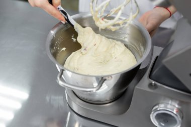 Pasta şefi karıştırıcının kasesine un ekler..