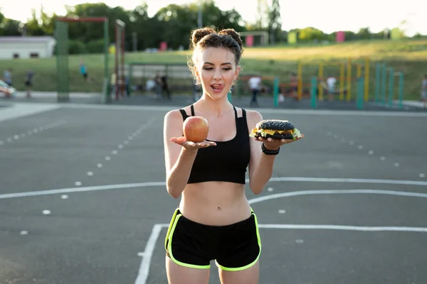Portrait Young Woman Burger One Hand Apple Other Hand Stadium — Stock Photo, Image