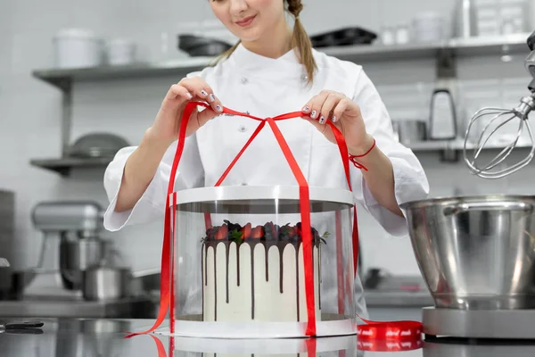 Pastry chef packs the cake in a fancy box.