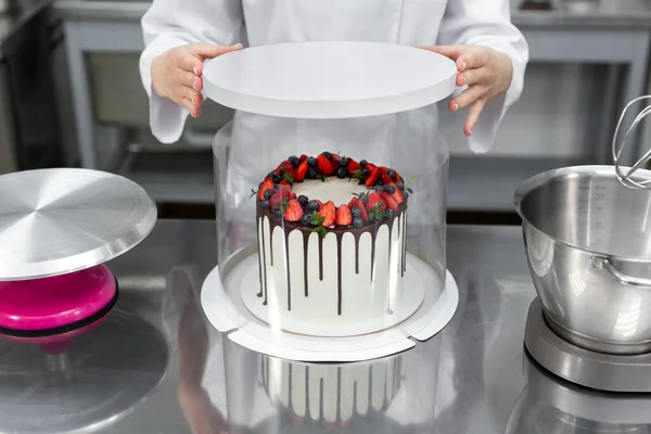 Pastry chef packs the cake in a fancy box.