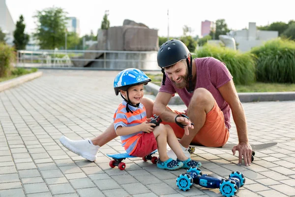 Glücklicher Vater Und Sohn Helmen Spielen Park Mit Einem Roboterauto Stockfoto