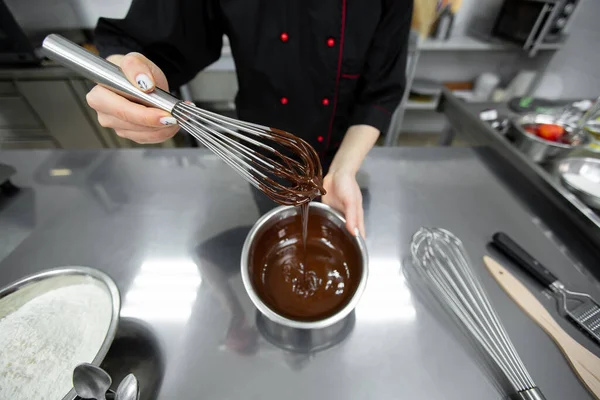 stock image The pastry chef mixes the chocolate ganache with a whisk.