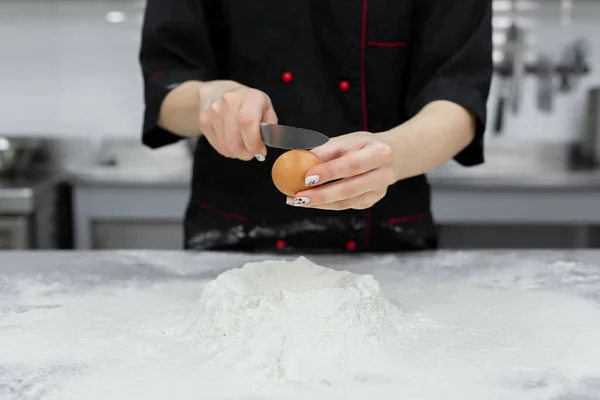 stock image Pastry chef cracking an egg over white flour