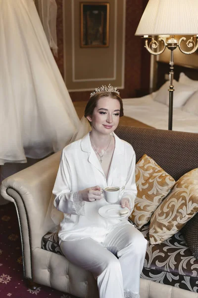 美しい花嫁です午前中にシルクパジャマ彼女の手にコーヒーのカップを保持しています — ストック写真