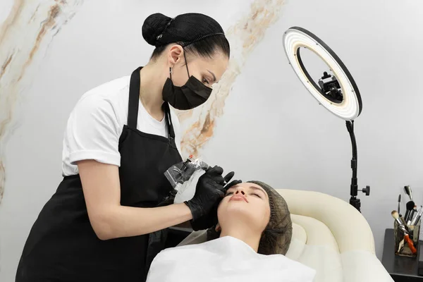 Permanent eyebrow makeup procedure. Eyebrow tattooing, the process in the salon.