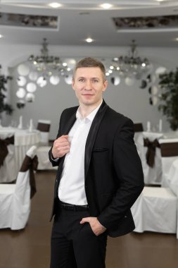 Restoranda takım elbiseli neşeli bir genç.