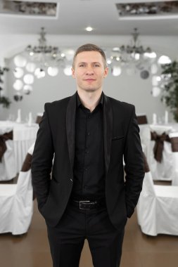 Restoranda takım elbiseli yakışıklı bir genç.